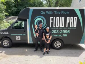 Flow Pro Plumbing and Drain Cleaning team standing in front of company service truck, trusted plumber Manchester NH providing professional plumbing and drain cleaning services.